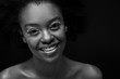 © LIGHTFIELD STUDIOS - black and white photo of cheerful african american woman isolated on black