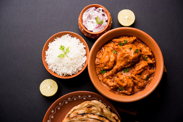 Wall Mural - Murgh Makhani / Butter chicken tikka masala served with roti / Paratha and plain rice along with onion salad. selective focus