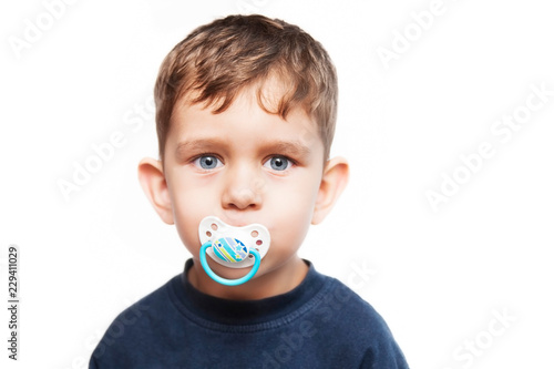 Fotomural Little boy with a serious face and with pacifier in his mouth on a white backgro