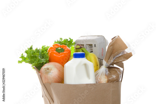 Fotografía Brown eco friendly grocery bag with bottle of milk, carton of eggs, bag of bread, bananas, lettuce, bell pepper and onion, isolated on white