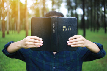 Wall Mural - A woman is holding and hug the bible in the morning. Hands folded in prayer on a Holy Bible in life concept. worship and religion. copy space