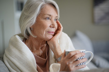 Wall Mural -  Cosy ooking senior woman at home with hot drink