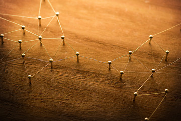 Wall Mural - Connecting networks. Two separate network being connected with gold wire. Networking, social media, internet communication abstract concept image. Web of gold wires on rustic wood.