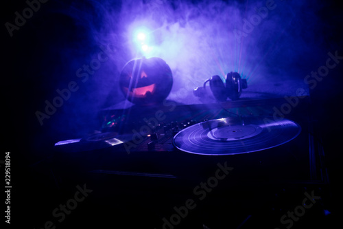 Halloween Pumpkin On A Dj Table With Headphones On Dark Background