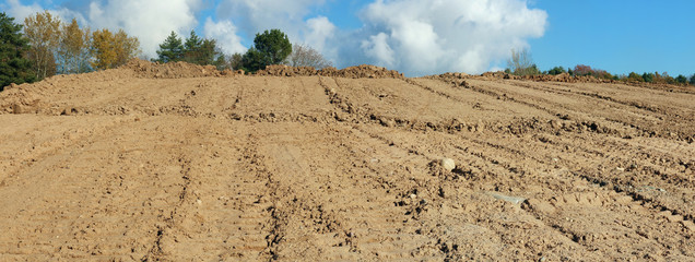 A large pile of sand  on a autumn forest  construction site. Panoramic collage