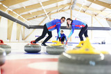 Fototapeta  - Rozgrywki curlingowe.  Zawodnik szczotkuje lód kierując kamień do domu