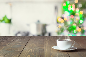 Wall Mural - Empty wooden tabletop for display products and blurred kitchen with Christmas tree as background.