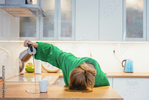 Cuadros en Lienzo Tired woman sleeping on the table in the kitchen at breakfast