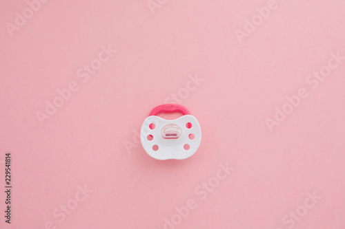 Fotografija  Baby pink pacifier with rubber soother isolated on pink background