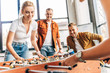 © LIGHTFIELD STUDIOS - cropped shot of happy casual business people playing table football at office and having fun together