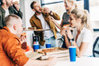 © LIGHTFIELD STUDIOS - group of happy young entrepreneurs eating pizza for lunch together while working on startup at office