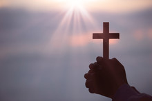 Silhouette Of Teen Girl Hands Holding Wooden Cross On Sunrise Background, Crucifix, Symbol Of Faith.