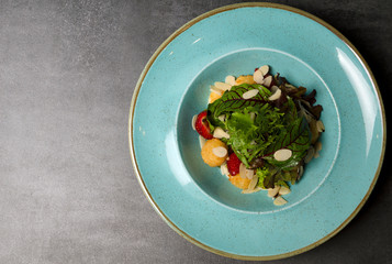 Wall Mural - Salad with strawberries and mozzarella cheese on a blue plate