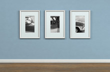 A Sequence Of Three Framed Hanging Pictures On A Flat Blue Wall In A House With Shiny Wooden Floors - 3D Render