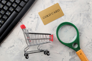 The concept of online shopping. Composition with discount cards and shopping trolley on a light background