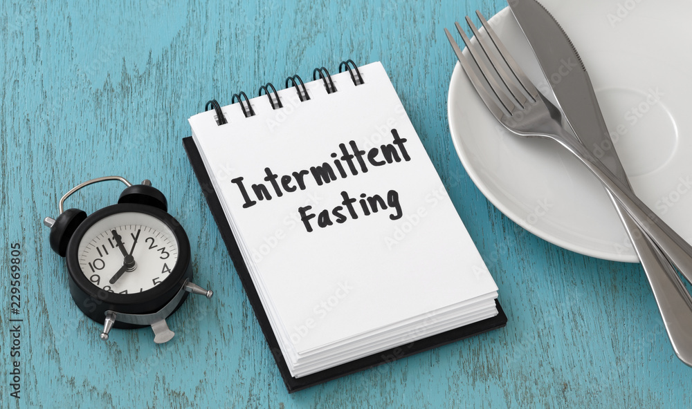 Intermittent fasting concept on blue table - obrazy, fototapety, plakaty 