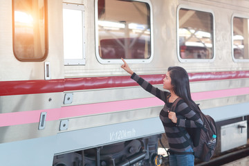 young traveler woman with backpack checking destination from blank computer white board before getting on the train