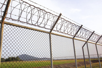 Metal fence wire, War and sky in the background in Phuket Thailand