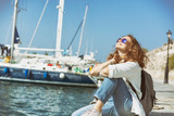 Fototapeta Londyn - Happy beautiful young woman woman on sea and port background, travel, vacation at sea
