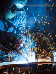 worker with protective mask welding metal