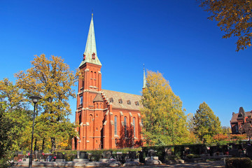 old church made of orange bricks and cemetery on sunny autumn day in Trinec, Czech Republic