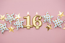 Number 16 Gold Candle And Stars On A Pastel Pink Background