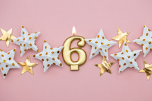 Number 6 Gold Candle And Stars On A Pastel Pink Background