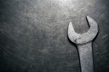 Old wrench on metal background