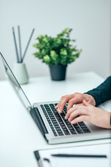 Close-up image of female person using laptop.