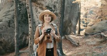 Active Healthy Caucasian Woman Taking Pictures With An Vintage Film Camera On A Forest Rocks