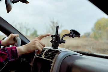 car driver hand point finger using smartphone application with map navigator to find the way f