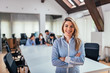 © bnenin - Portrait of a smiling attractive businesswoman with crossed arms in a meeting room.