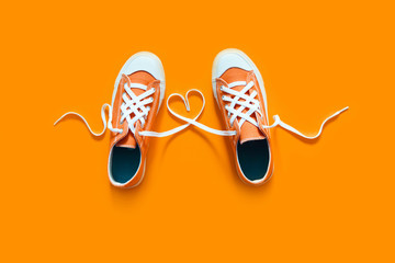 Short low  bright sneakers on a orange background.