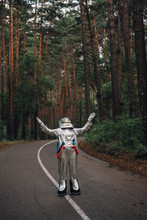 Spaceman Exploring Nature, Hitchhiking On Road In Forest