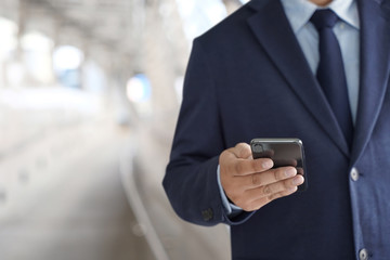 Business man hold the smartphone on the street  and copy space.