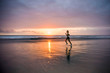© TheVisualsYouNeed - silhouette of fit and athletic Asian Chinese sporty woman running on beautiful beach doing jogging workout on sunset in fitness healthy lifestyle and summer outdoors activity