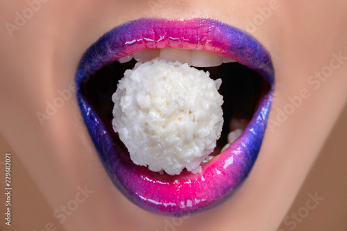 Fotografía closeup of female colorful glitter lips with coconut candy
