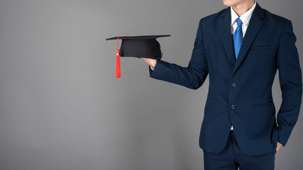 business man is holding graduation hat, business education concept