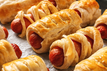 Freshly baked tasty sausage rolls on baking dish, closeup