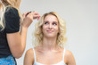 © Вячеслав Чичаев - The work of a professional make-up artist, beautician, makes makeup on the face of a blonde girl with shadows on the eyes.