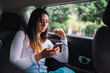 © kikearnaiz - Young woman using smartphone in car