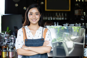 Asian women Barista smiling and using coffee machine in coffee shop counter - Working woman small business owner food and drink cafe concept