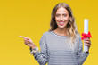 © Krakenimages.com - Beautiful young blonde woman holding degree certificate over isolated background very happy pointing with hand and finger to the side