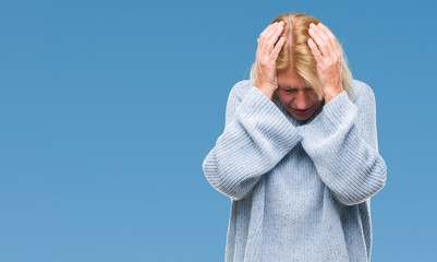 Canvas Print - Middle age blonde woman wearing winter sweater over isolated background suffering from headache desperate and stressed because pain and migraine. Hands on head.