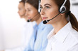 © rogerphoto - Call center. Group of operators at work. Focus on beautiful business woman in headset