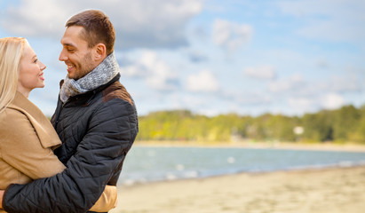 Sticker - love, relationships and people concept - happy couple hugging over autumn beach background