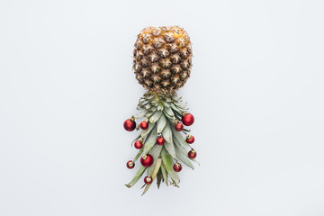 Wall Mural - top view of red christmas balls on fresh pineapple isolated on white