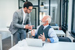 © bnenin - Senior and young man discussing at work.