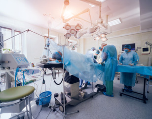 Wall Mural - Process of trauma surgery operation. Group of surgeons in operating room with surgery equipment.