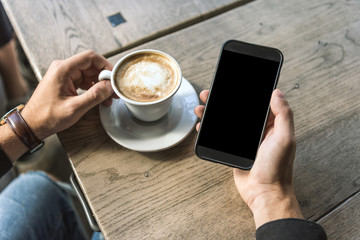 Poster - cropped shot of man with cup of cappuccino using smartphone with blank screen
